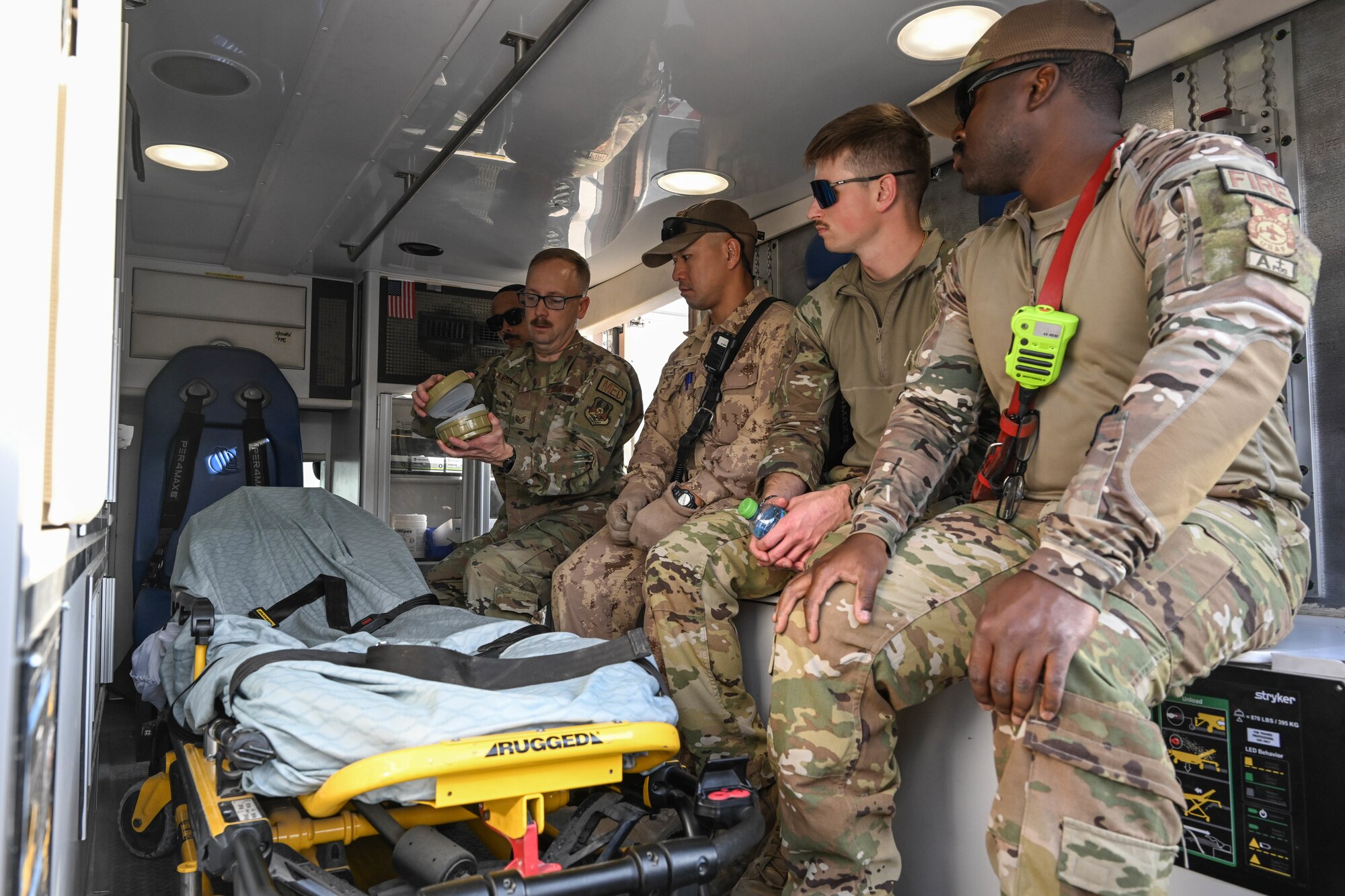 Men in uniform sit in an ambulance.