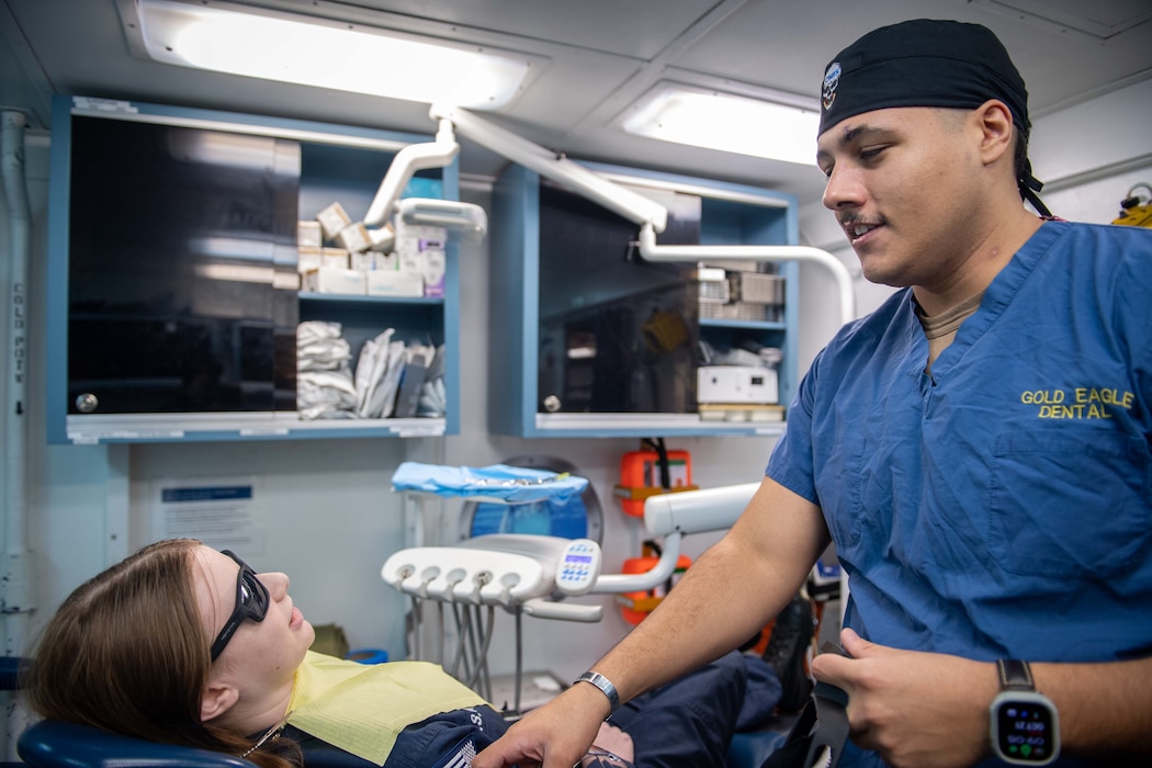 241021-N-CT713-1084 SAN DIEGO (Oct. 21, 2024) Hospital Corpsman 3rd Class Vlad Teodore, a native of Grayson, Georgia, right, prepares Yeoman Seaman Ava Gray, a native of Colorado Springs, Colorado, for a dental procedure aboard Nimitz-class aircraft carrier USS Carl Vinson (CVN 70). Vinson is currently pierside in its homeport of San Diego. (U.S. Navy photo by Mass Communication Specialist Seaman Amber Rivette)