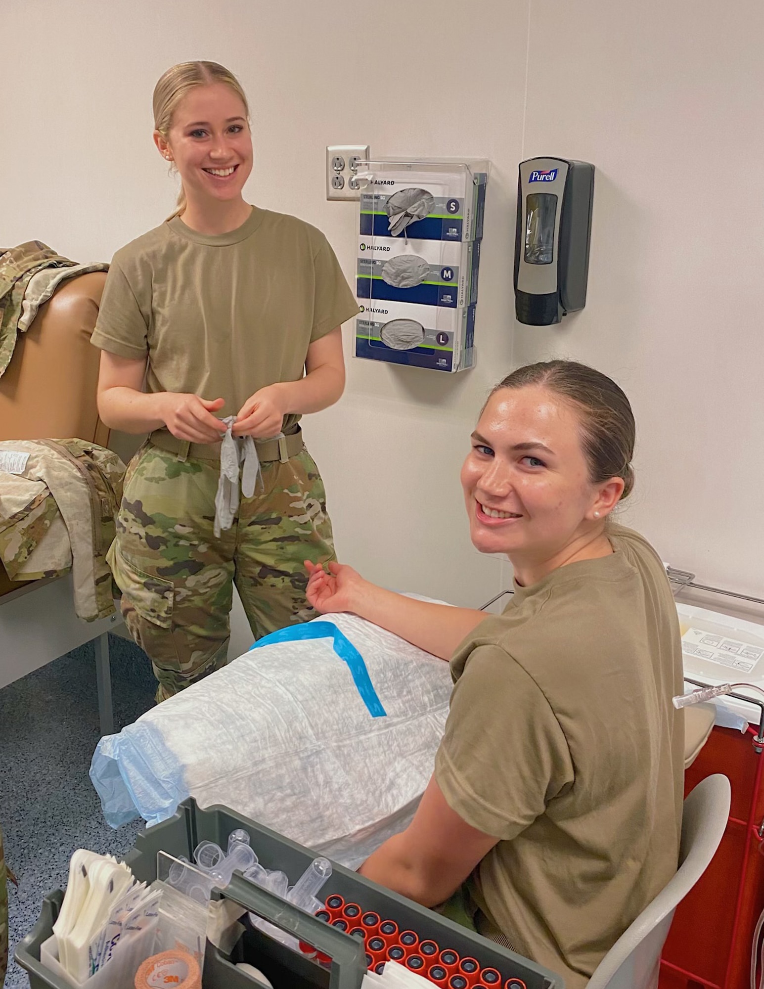 U.S. Air Force Airman 1st Class Bridget Johnson, right, gets her blood drawn by Airman 1st Class Claire Monroe, left, at Fort Sam Houston, Texas, April 19, 2022.