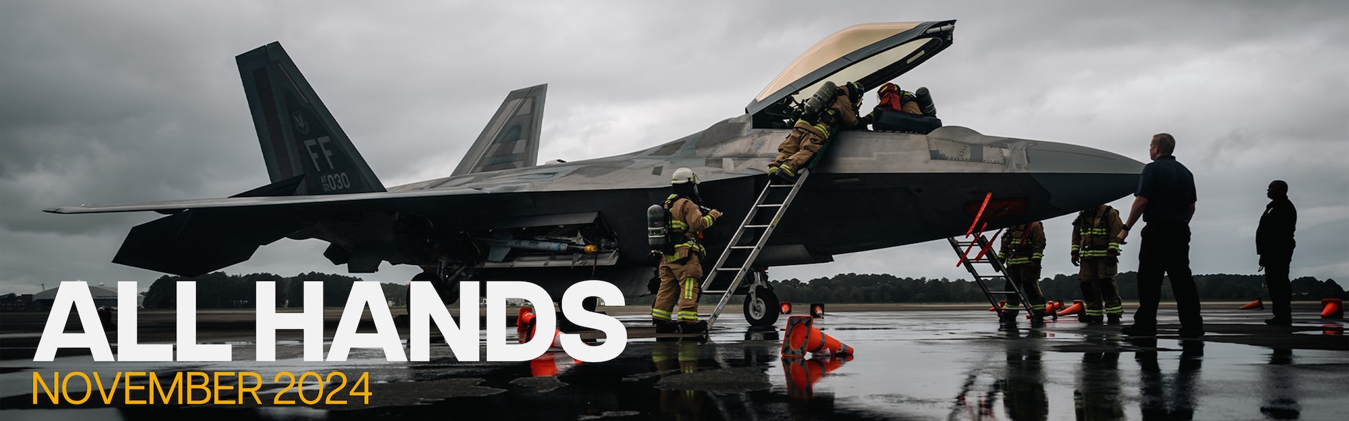 Sailors inspecting jet on the fleet with grey cloudy background