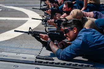 U.S. Sailors fire M4 rifles during a gun shoot on the flight deck of the Arleigh Burke-class guided-missile destroyer USS Michael Murphy (DDG 112).