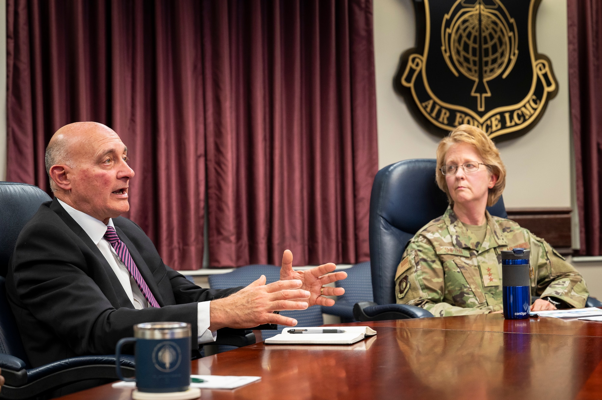 people sitting around a conference table to conduct a virtual briefing
