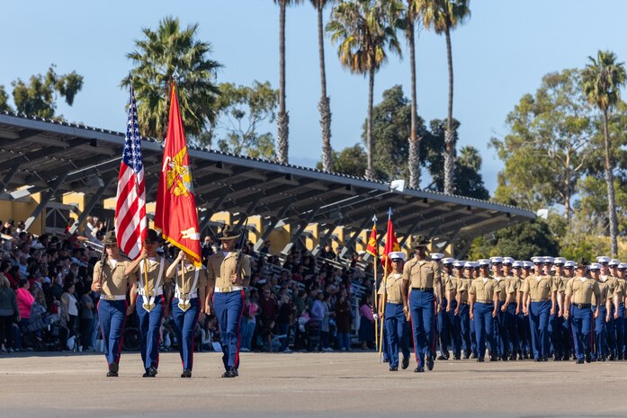 U.S. Marines with the regimental color guard lead Delta Company, 1st Recruit Training Battalion, as they march across the parade deck during their graduation ceremony at Marine Corps Recruit Depot San Diego, California, Nov. 1, 2024. Graduation took place at the completion of the 13-week transformation, which included training for drill, marksmanship, basic combat skills, and Marine Corps customs and traditions. (U.S. Marine Corps photo by Cpl. Alexander O. Devereux)