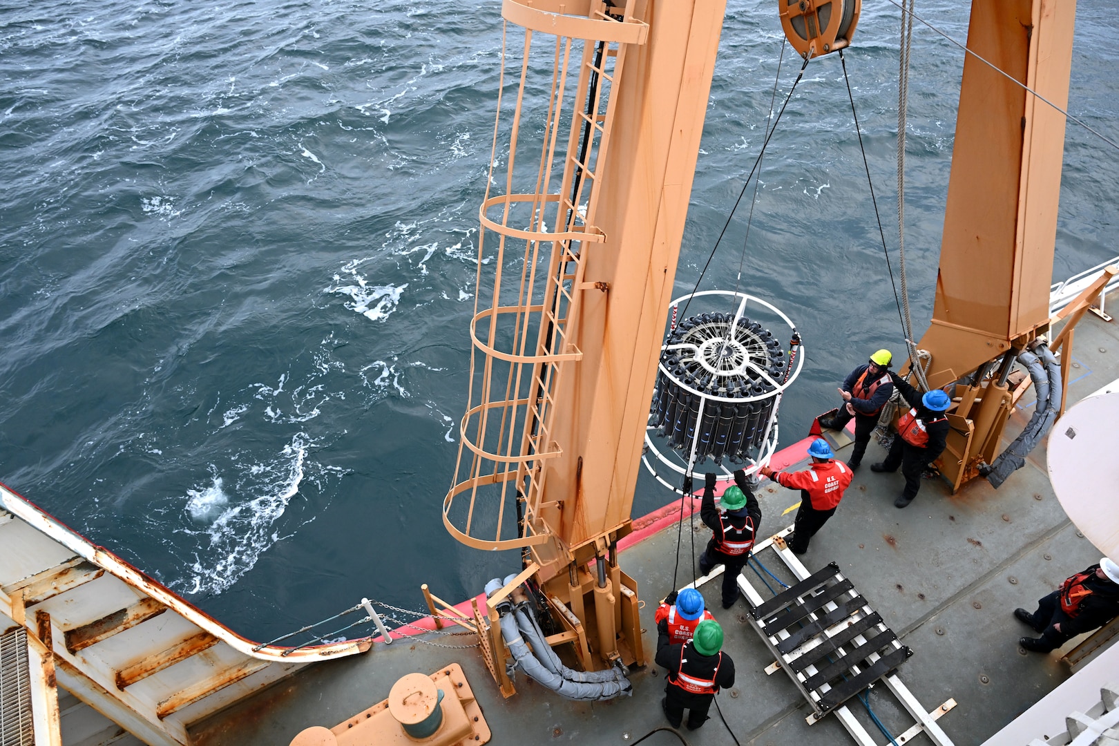 U.S. Coast Guard Cutter Healy (WAGB 20) crewmembers retrieve a Conductivity, Temperature, and Depth (CTD) instrument from the Chukchi Sea, Oct. 26, 2024. Healy’s crew has supported the embarked scientists by deploying equipment and instruments for collecting water samples and data throughout their Arctic deployment. U.S. Coast Guard photo by Senior Chief Petty Officer Matt Masaschi.