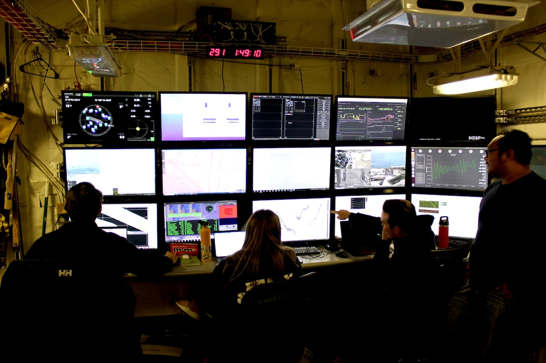 Members of the hydrographic team from the National Oceanic and Atmospheric Administration Ship Fairweather and the University of New Hampshire analyze mapping data in the U.S. Coast Guard Cutter Healy’s (WAGB 20) computer lab while the cutter transits the Beaufort Sea, Oct. 16, 2024. Healy’s crew supported an embarked science team during the first phase and conducted the Alaskan Arctic Coast Port Access Route Study (AACPARS) and opportunistic mapping, which included bathymetric mapping in the Chukchi and Beaufort Seas. U.S. Coast Guard photo by Lt. j.g. Haley Howard.