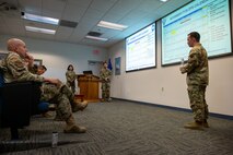 Three Airmen deliver a presentation for their class.