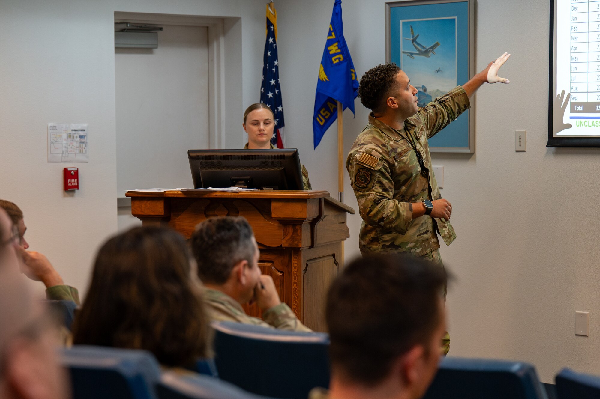 Two Airmen deliver a presentation to their class.