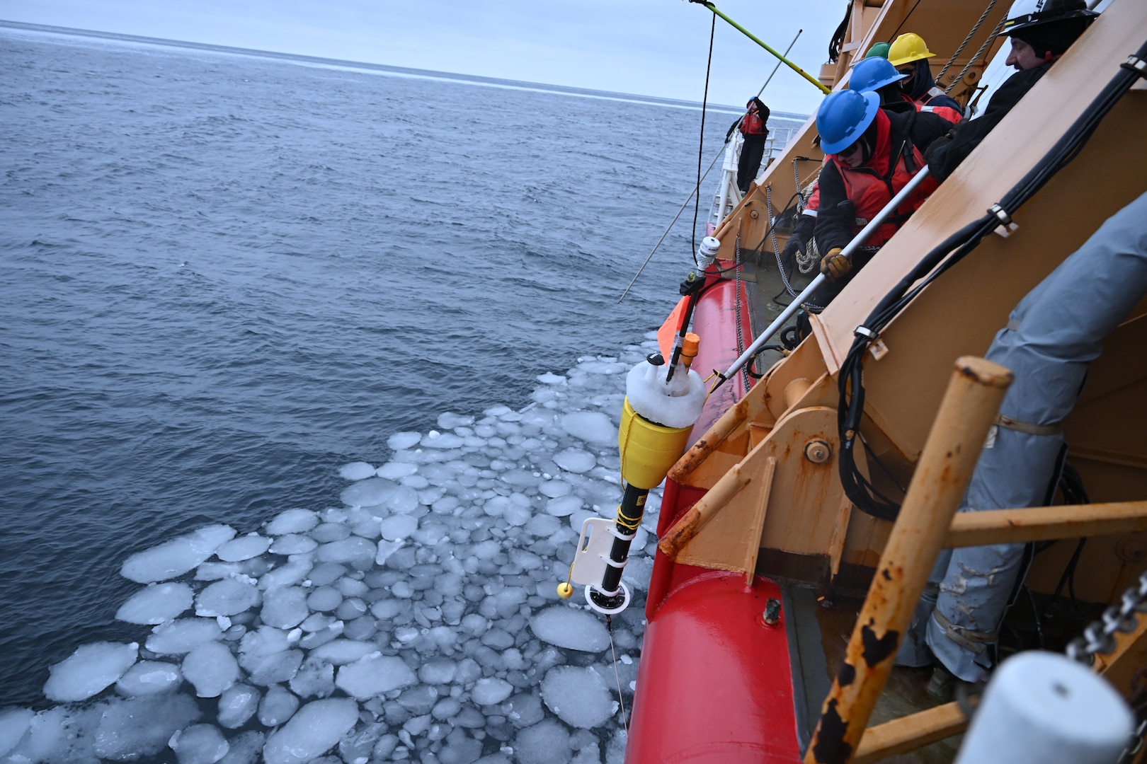 U.S. Coast Guard Cutter Healy (WAGB 20) crewmembers retrieve a Surface Wave Instrument Float with Tracking (SWIFT) drifter in the Chukchi Sea, Oct. 30, 2024. Healy’s crew has supported the embarked scientists by deploying equipment and instruments for collecting water samples and data throughout their Arctic deployment. U.S. Coast Guard photo by Senior Chief Petty Officer Matt Masaschi.