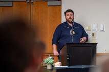 A Royal Navy Lt. Cmdr. delivers a presentation.