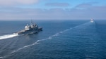The Ticonderoga-class guided-missile cruiser USS Chosin (CG 65) approaches the Lewis and Clark-class dry cargo ship USNS Washington Chambers (T-AKE 11) in preparation for an at-sea demonstration of the Transferrable Reload At-sea Method (TRAM) while underway in the Pacific Ocean Oct. 11, 2024. Sailors aboard Chosin used the hydraulically- powered TRAM device to load an empty missile canister into the ship’s MK 41 Vertical Launching System (VLS) while off the coast of San Diego. (U.S. Navy photo by Mass Communication Specialist 2nd Class Charlotte Dudenhoeffer)