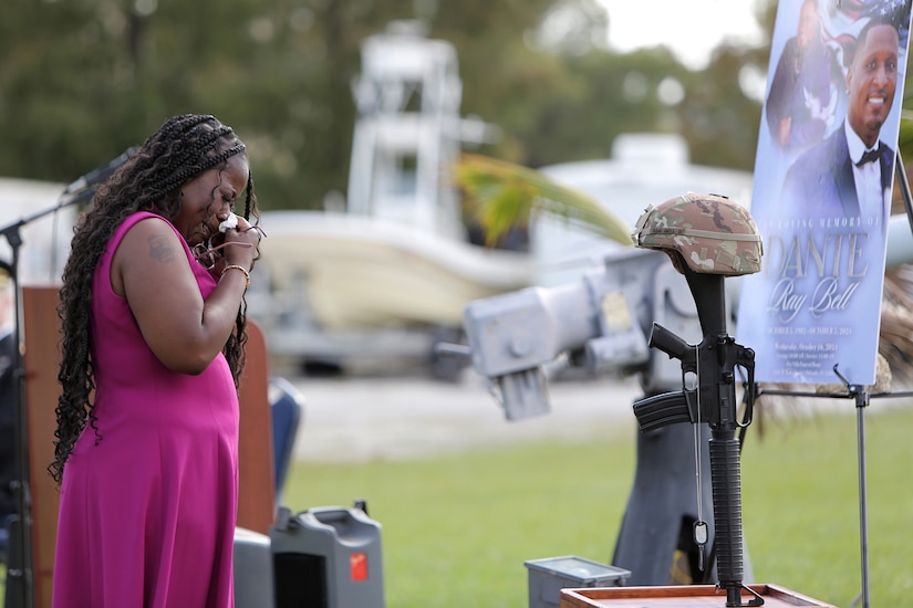 Cordelia Bell, wife of Staff Sgt. Dante Bell, takes a moment in front of Bell’s battle cross during a unit memorial ceremony for Bell who died last month in a training incident.