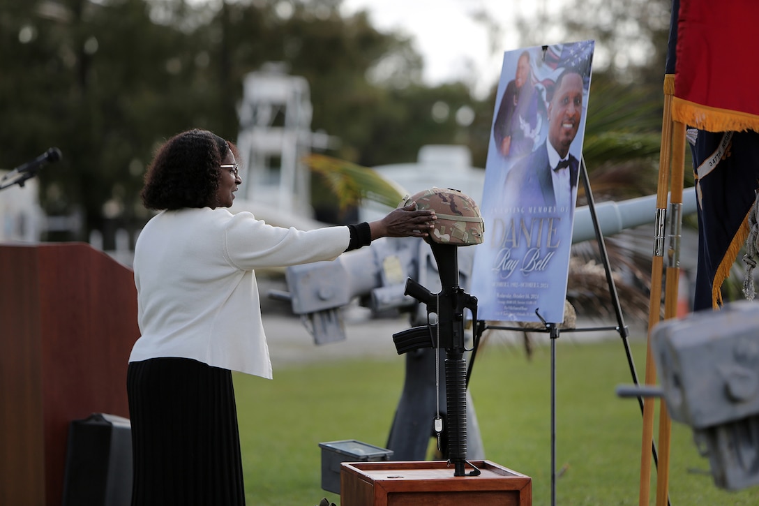 Carolyn Davis, mother of Staff Sgt. Dante Bell, lightly touches Bell’s helmet, in front of his battle cross during a unit memorial ceremony for Bell who died last month in a training incident.