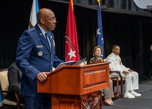 A man in a uniform speaks from a podium.