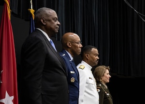 Military personnel stand at attention.