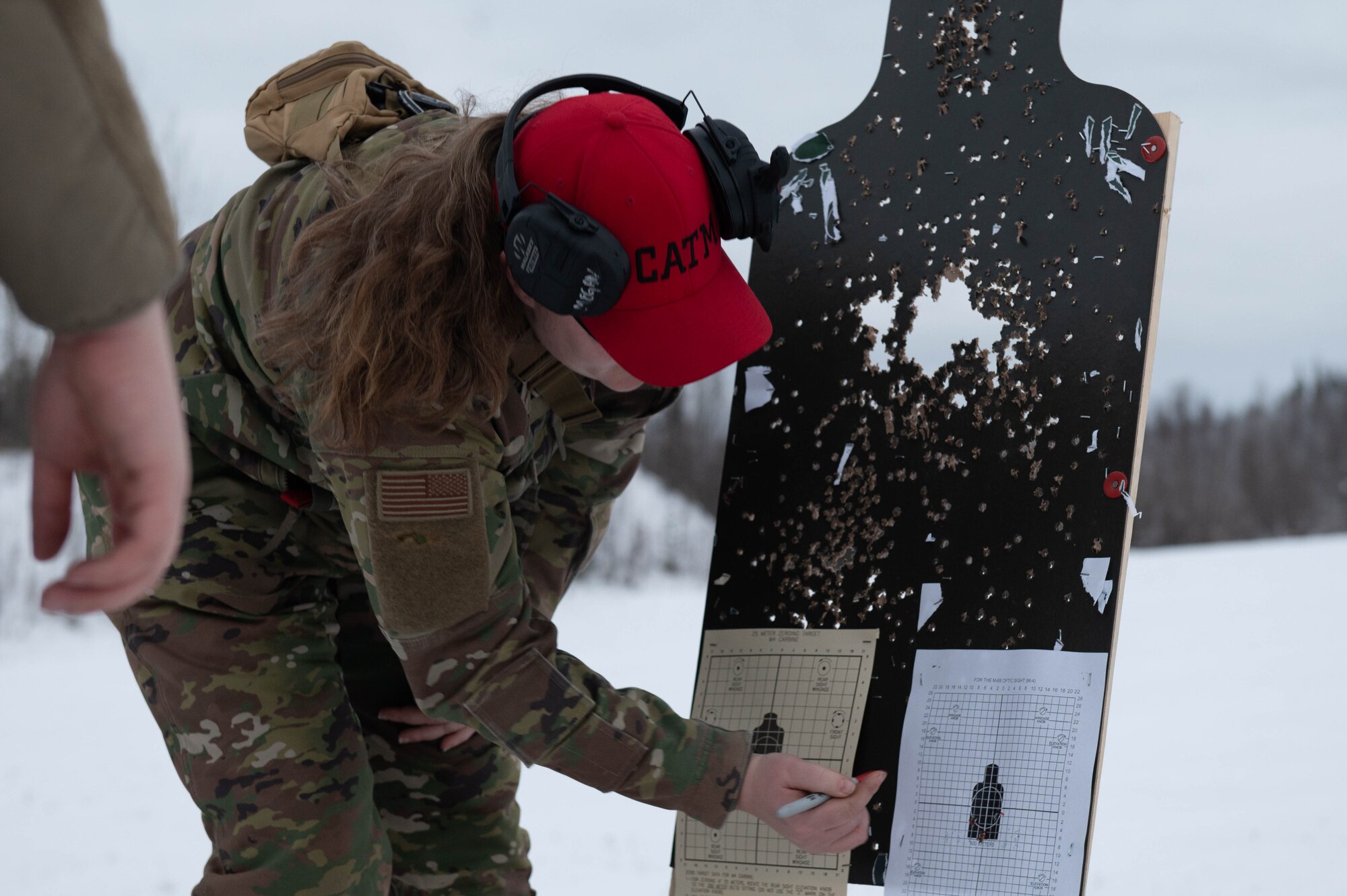 U.S. Air Force Senior Airman Megan Sheely-Alvarado, 354th Security Forces Squadron Combat Arms Training and Maintenance instructor, makes zeroing adjustments on a student’s target during an annual qualifications training course at Eielson Air Force Base, Alaska, Oct. 28, 2024.