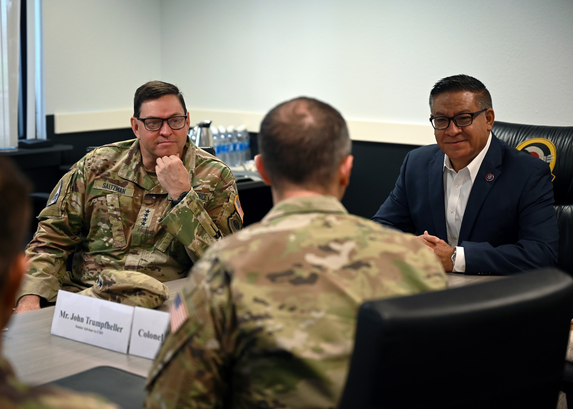 Three men sitting at table.