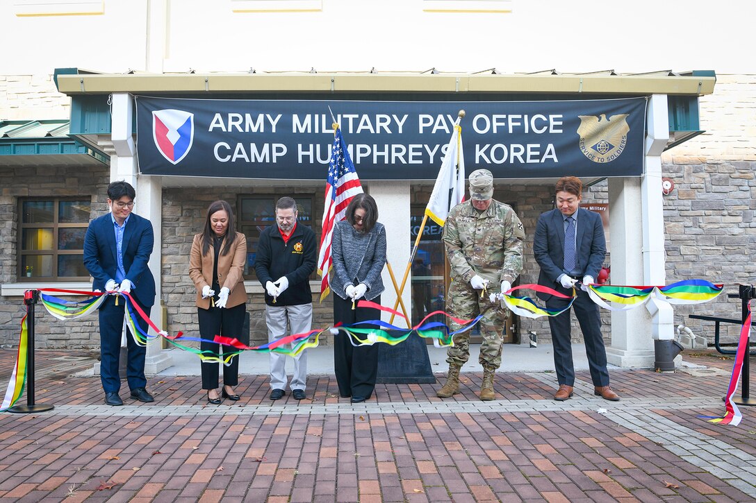 From left to right: Ki Sang Yi, Army Military Pay Office Korea Debt Management and Reserve Pay Section lead; Patty White; Patty White, AMPO Korea director; Daniel M. Hancock, U.S. Army Garrison Humphreys deputy to the commander; Mary Jelev, U.S. Army Financial Management Command Military Pay Operations director; Col. Nicholas Paavola, Eighth Army assistant chief of staff (G8); and Hyuk Mun, AMPO Korea deputy director, cut a ribbon at a special ceremony opening AMPO Korea at Camp Humphreys, South Korea, Oct. 31, 2024. USAFMCOM opened the new AMPO on Camp Humphreys as well as two satellite locations at Camps Walker and Casey. (U.S. Army photo by Cpl. Kianna Scott)