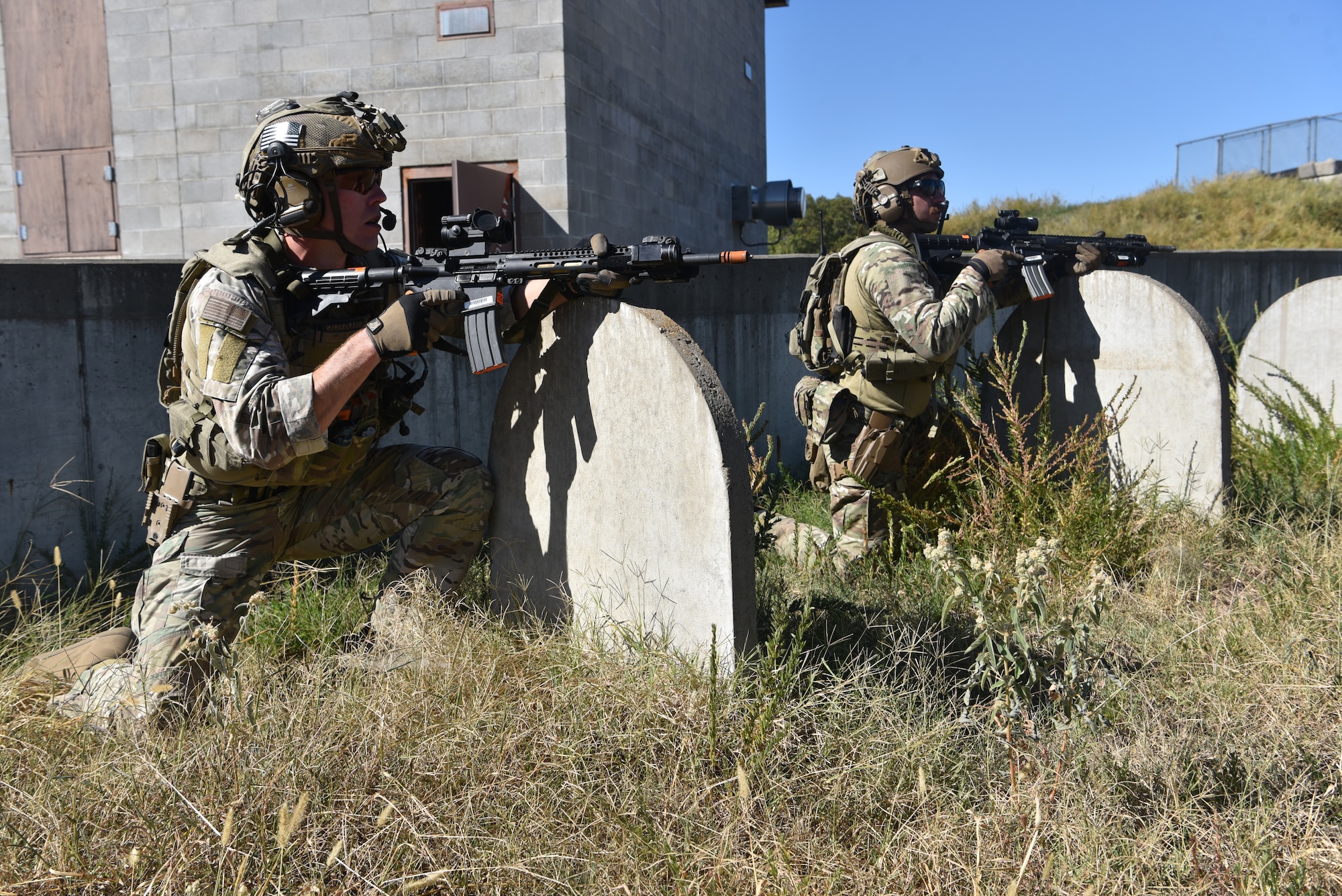 Technical Sgt. Jordan Jaquet (left), 90 GCTS formal training instructor, and Senior Amn. Dawson Gochee (right), 90 MSOS/TRF assaulter, participate in an urban recovery scenario during Joint Training Exercise 2024, at Fort Chaffee, Arkansas, October 15, 2024. During the three-week JTX, Twentieth Air Force Security Forces airmen refined critical response skills alongside the U.S. Office of Secure Transportation and Royal Marines. The exercise provided hands-on experience with advanced weapons handling, live-fire drills, and urban recovery scenarios, enhancing readiness for nuclear security operations. (U.S. Air Force Photo by 1st Lt. Jacqulyn Noffsinger)