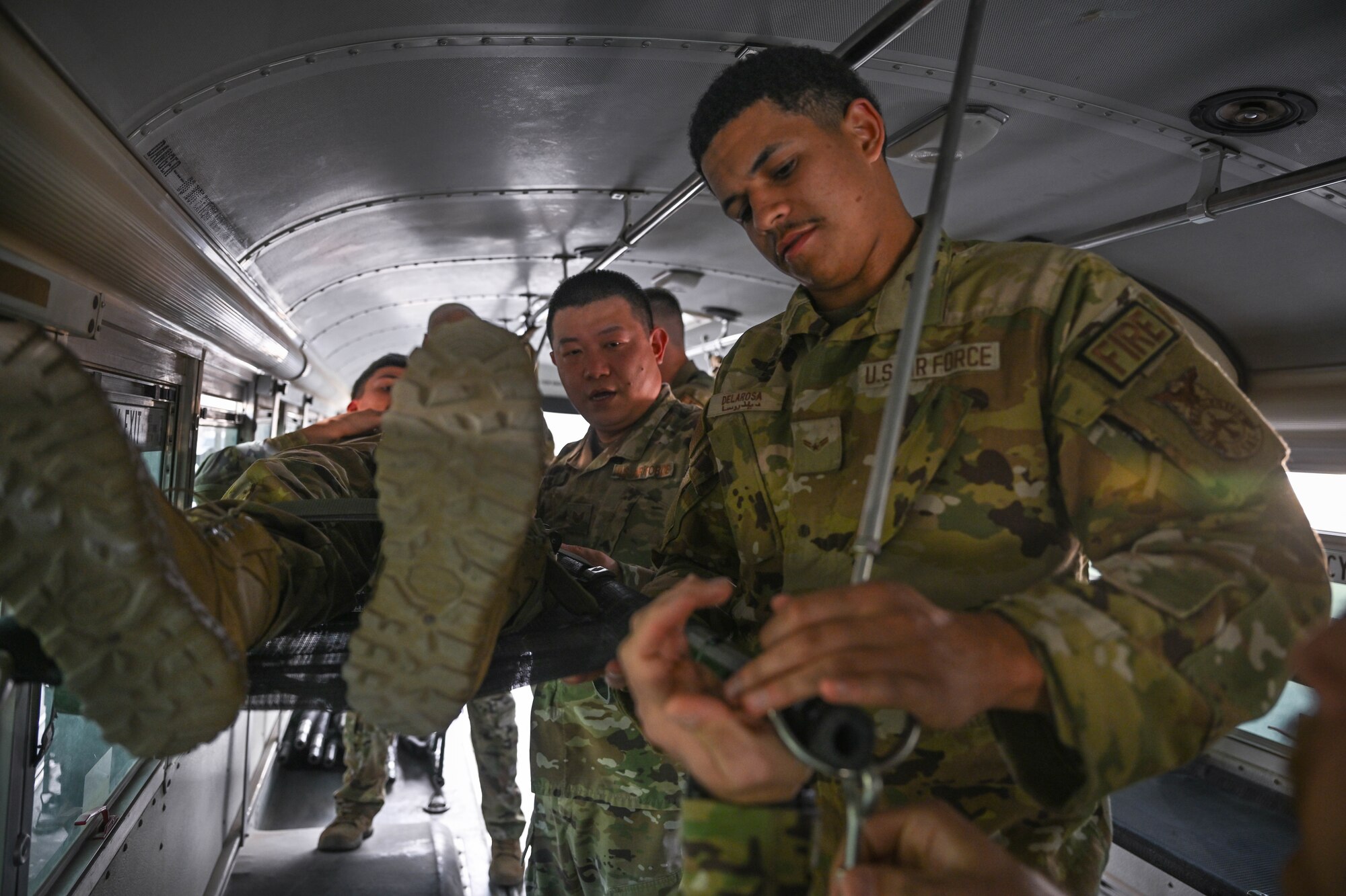 A man in uniform puts a litter handle into an O ring.