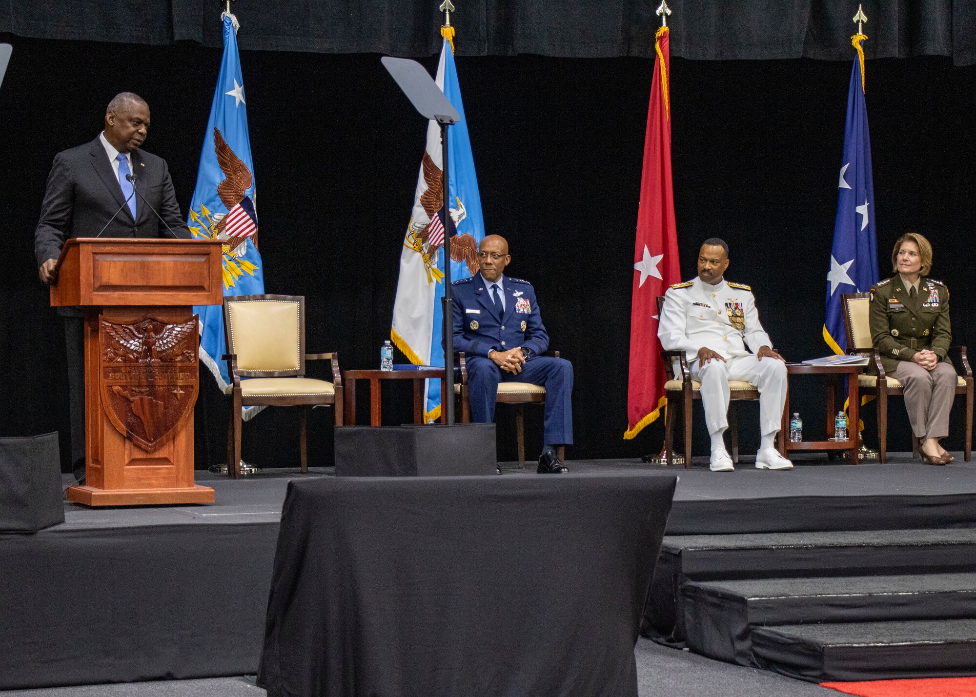 A man in a suit speaks from a podium.