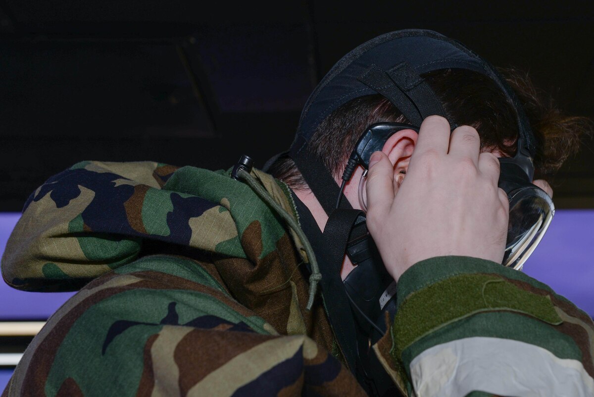 U.S. Air Force Senior Airman Connor Butler, 51st Operations Support Squadron air traffic controller, dons an earpiece under his mission oriented protective posture gear during Beverly Herd 25-1 at Osan Air Base, Republic of Korea, Oct. 29, 2024. The 51st OSS is working with the University of Oklahoma and the Air Force Flight Standards Agency to test, evaluate and create a high-tech transmitter to generate effective air-to-ground and ground-to-air communications for air traffic controllers. (U.S. Air Force photo by Staff Sgt. Kahdija Slaughter)