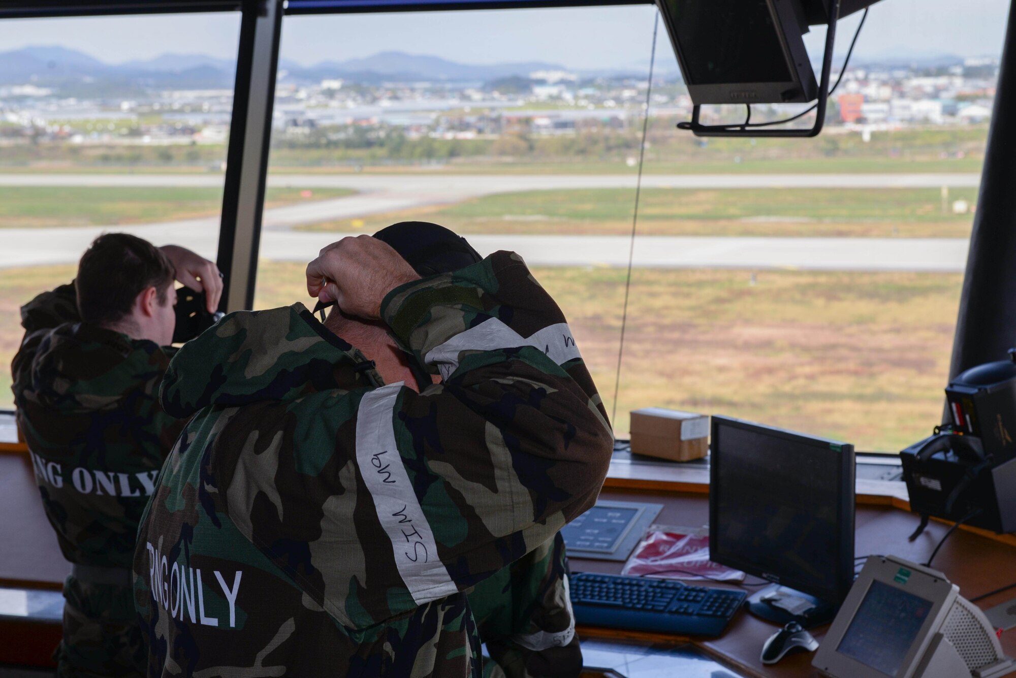 Airmen assigned to the 51st Operations Support Squadron don M-50 gas masks during Beverly Herd 25-1 at Osan Air Base, Republic of Korea, Oct. 29, 2024. The 51st OSS is working with the University of Oklahoma and the Air Force Flight Standards Agency to test, evaluate and create a high-tech transmitter to generate effective air-to-ground and ground-to-air communications for air traffic controllers. (U.S. Air Force photo by Staff Sgt. Kahdija Slaughter)