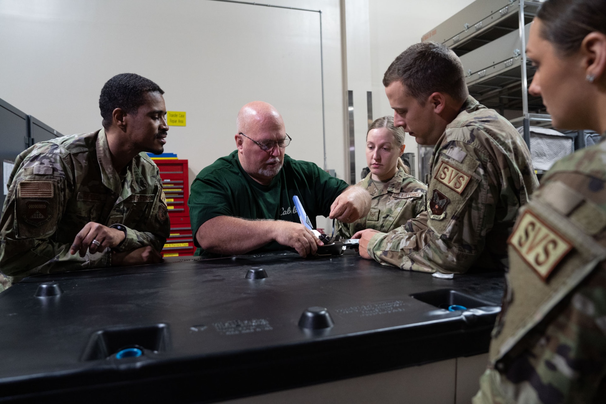 Airmen train with a civilian in the warehouse of AFMAO.