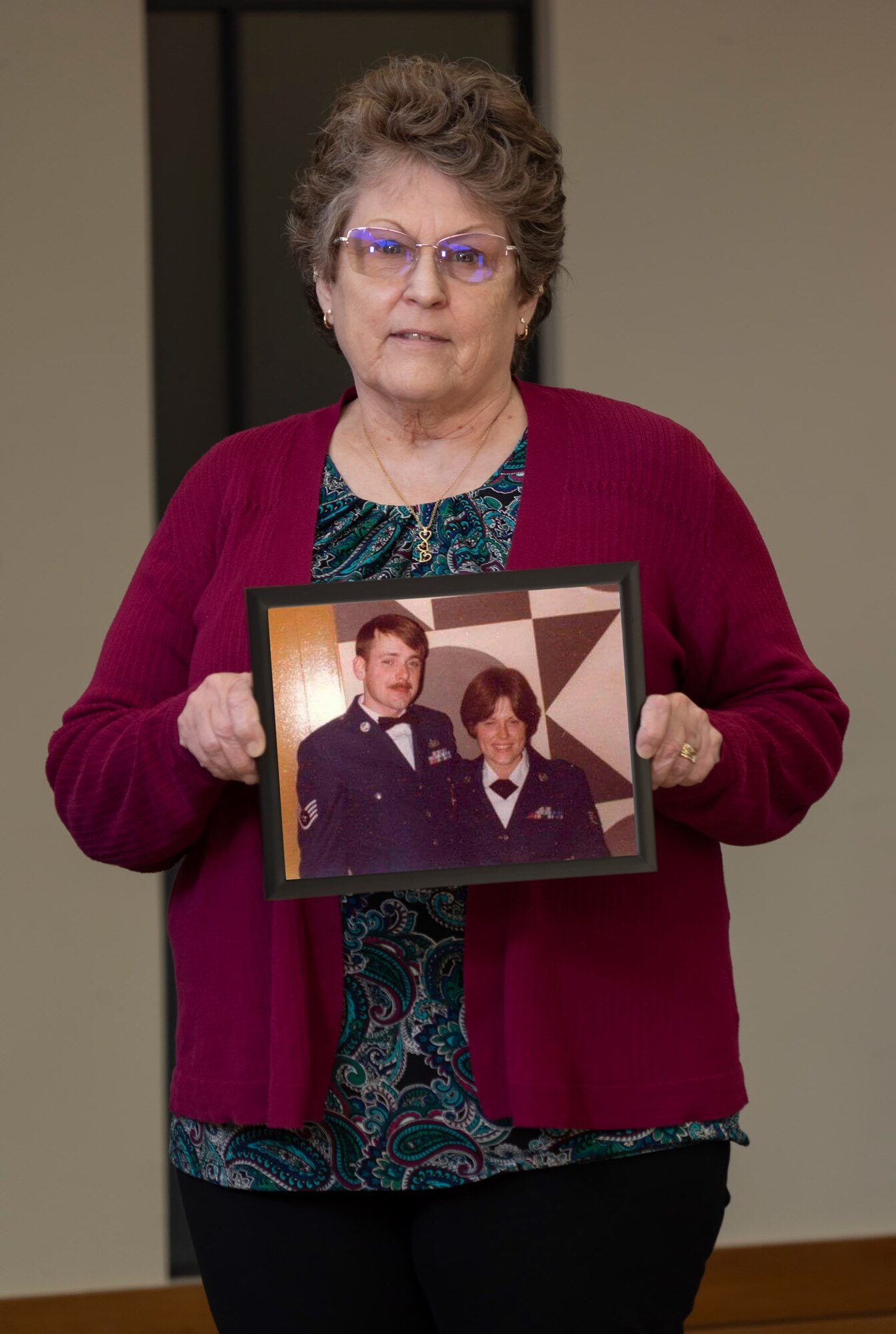 A woman stand with a photo of herself.