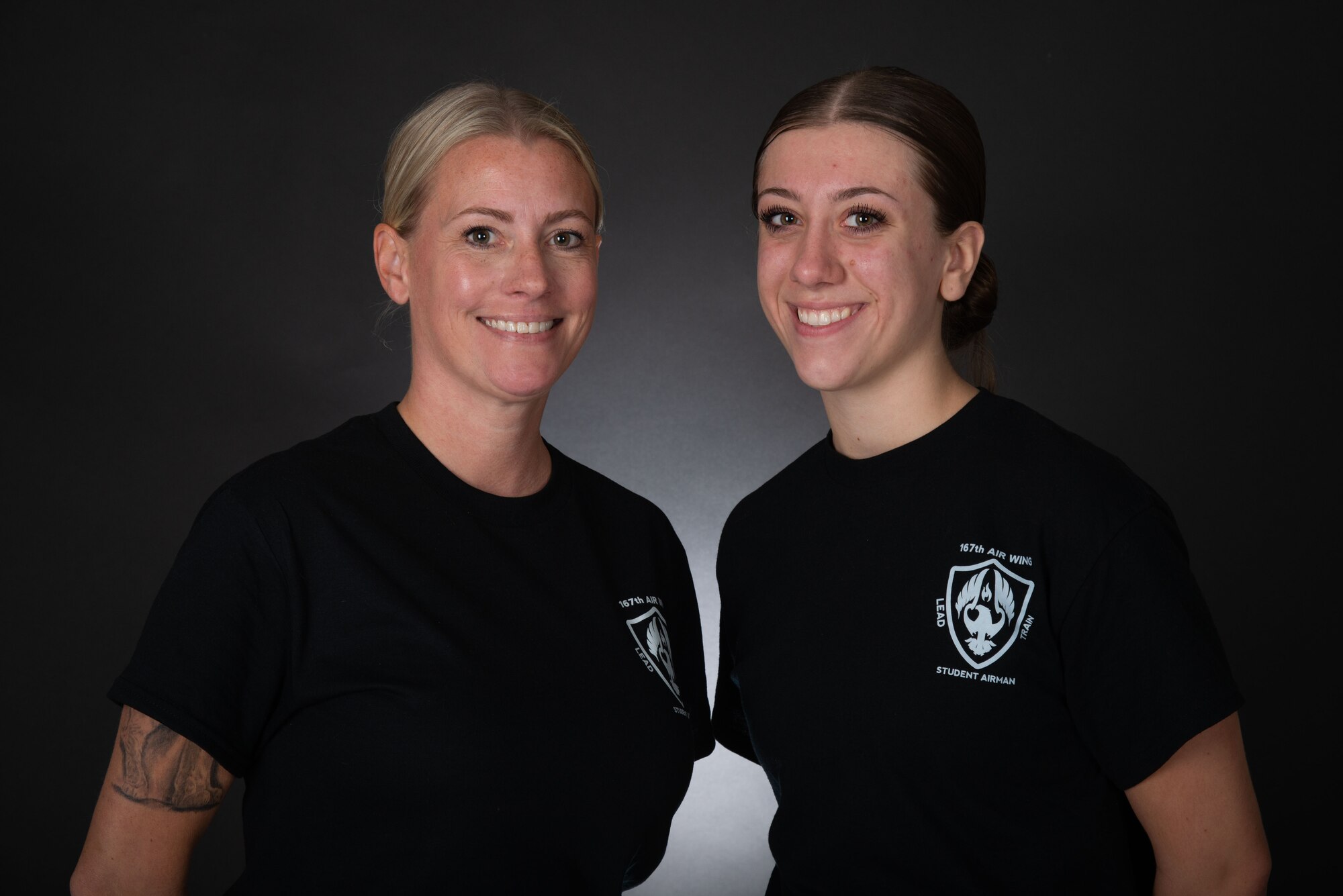 Two women pose for a studio photo