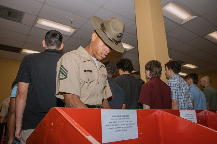 U.S. Marine Corps Staff Sgt. Joshua Brown, a drill instructor with Receiving Company, Support Battalion, inspects recruits’ belongings during Bravo Company, 1st Recruit Training Battalion, receiving event at Marine Corps Recruit Depot San Diego, California, Oct. 28, 2024. During the receiving process, recruits are taken to the United States Organizations for accountability, checked for contraband, given haircuts, make scripted phone calls home, and issued gear required for training. (U.S. Marine Corps photo by Cpl. Sarah M. Grawcock)
