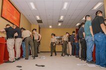 U.S. Marine Corps drill instructors with Receiving Company, Support Battalion, inspect recruits’ belongings during Bravo Company, 1st Recruit Training Battalion, receiving event at Marine Corps Recruit Depot San Diego, California, Oct. 28, 2024. During the receiving process, recruits are taken to the United States Organizations for accountability, checked for contraband, given haircuts, make scripted phone calls home, and issued gear required for training. (U.S. Marine Corps photo by Cpl. Sarah M. Grawcock)