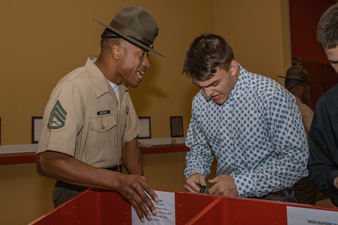 U.S. Marine Corps Staff Sgt. Joshua Brown, a drill instructor with Receiving Company, Support Battalion, instructs a recruit during the Bravo Company, 1st Recruit Training Battalion, receiving event at Marine Corps Recruit Depot San Diego, California, Oct. 28, 2024. During the receiving process, recruits are taken to the United States Organizations for accountability, checked for contraband, given haircuts, make scripted phone calls home, and issued gear required for training. (U.S. Marine Corps photo by Cpl. Sarah M. Grawcock)