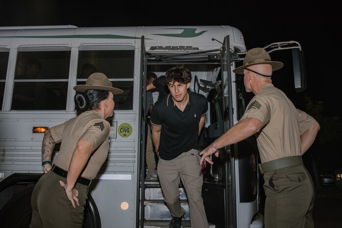 U.S. Marine Corps drill instructors with Receiving Company, Support Battalion, instruct recruits with Bravo Company, 1st Recruit Training Battalion, to get off a bus as part of a receiving event at Marine Corps Recruit Depot San Diego, California, Oct. 28, 2024. During the receiving process, recruits are taken to the United States Organizations for accountability, checked for contraband, given haircuts, make scripted phone calls home, and issued gear required for training. (U.S. Marine Corps photo by Cpl. Sarah M. Grawcock)