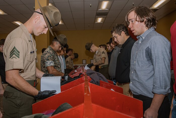 U.S. Marine Corps drill instructors with Receiving Company, Support Battalion, inspect recruits’ belongings during the Bravo Company, 1st Recruit Training Battalion, receiving event at Marine Corps Recruit Depot San Diego, California, Oct. 28, 2024. During the receiving process, recruits are taken to the United States Organizations for accountability, checked for contraband, given haircuts, make scripted phone calls home, and issued gear required for training. (U.S. Marine Corps photo by Cpl. Sarah M. Grawcock)