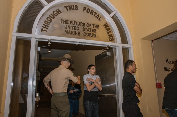 U.S. Marine Corps recruits with Bravo Company, 1st Recruit Training Battalion, pass through the silver doors as part of a receiving event at Marine Corps Recruit Depot San Diego, California, Oct. 28, 2024. During the receiving process, recruits are taken to the United States Organizations for accountability, checked for contraband, given haircuts, make scripted phone calls home, and issued gear required for training. (U.S. Marine Corps photo by Cpl. Sarah M. Grawcock)