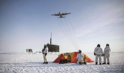 Air Force C-130 Hercules flies over group of Navy SEALS, Norwegian naval special operations commandos, and attack submarine USS Hampton during exercise Arctic Edge, March 9, 2024 (U.S. Navy/Jeff Atherton)