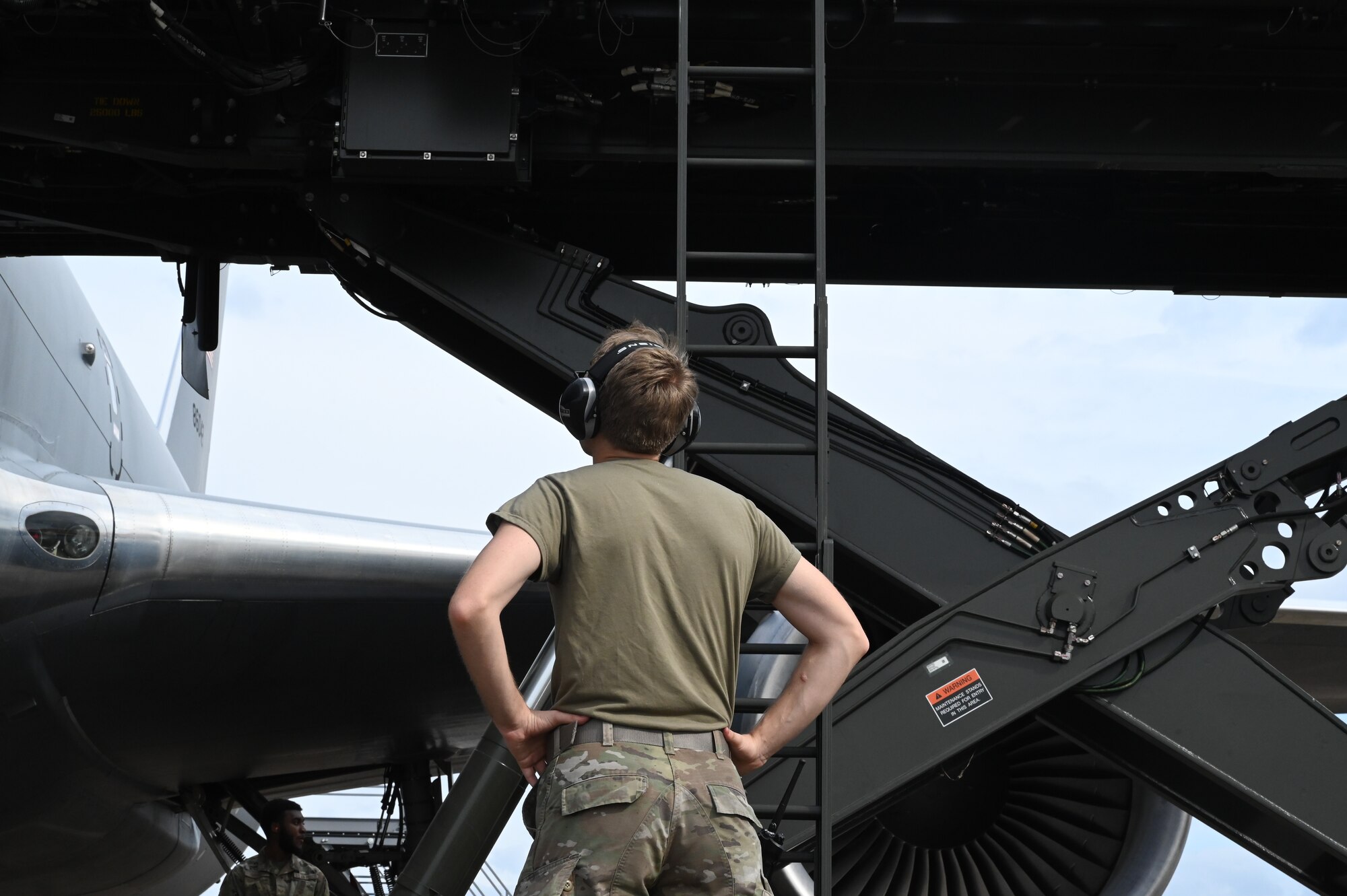 a person watches a lift reach an aircraft.