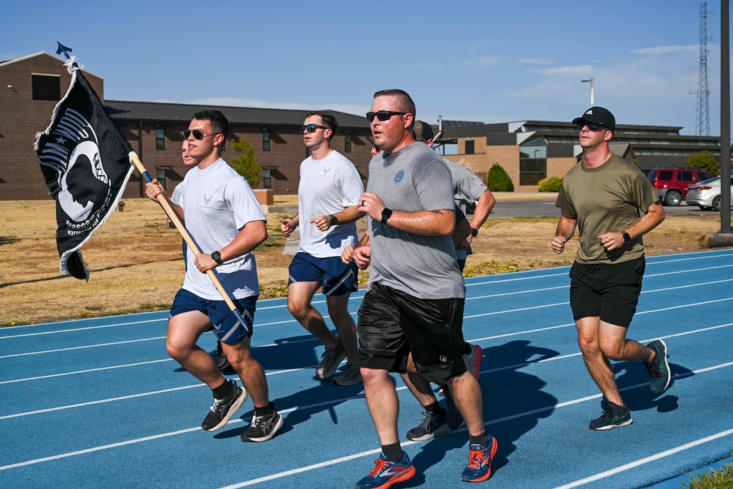 U.S. Air Force Master Sgt. Daniel Bagwell (left), 97th Civil Engineer Squadron (CES) first sergeant, runs with Airmen from the 97 CES during a Prisoner of War/Missing in Action run at Altus Air Force Base, Oklahoma, Sept. 20, 2024. Bagwell has been a first sergeant since 2020. (U.S. Air Force photo by Senior Airman Miyah Gray)