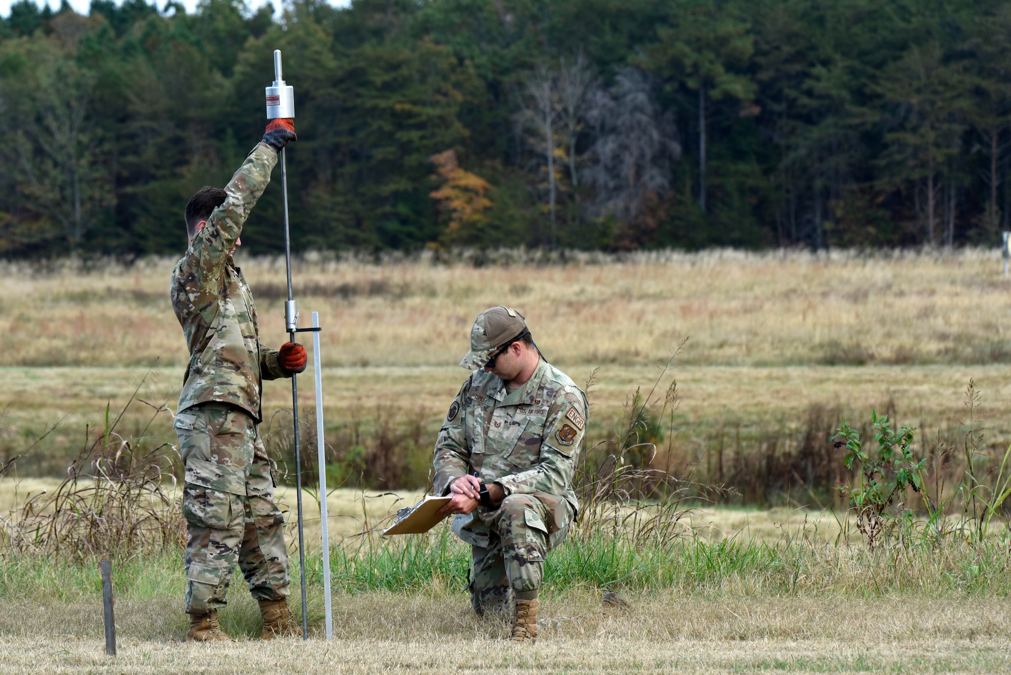 U.S. Air Force Senior Airman Seth Casey (left), and Tech. Sgt. Keegan Lumley (right), 145th Civil Engineering Squadron, ready a site for a Mobile Aircraft Arresting System during a Combat Readiness Inspection (CRI) held at the North Carolina Air National Guard (NCANG) Regional Training Site (RTS), Stanly County, Nov. 2, 2024.