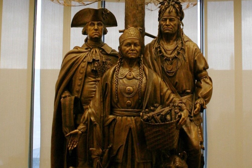 A large bronze statue of two Native Americans and Gen. George Washington.