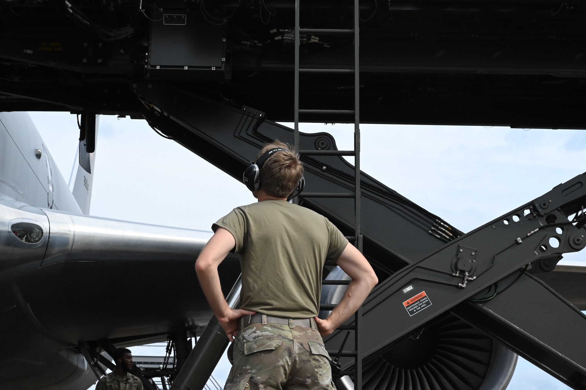 a person watches a lift reach an aircraft.