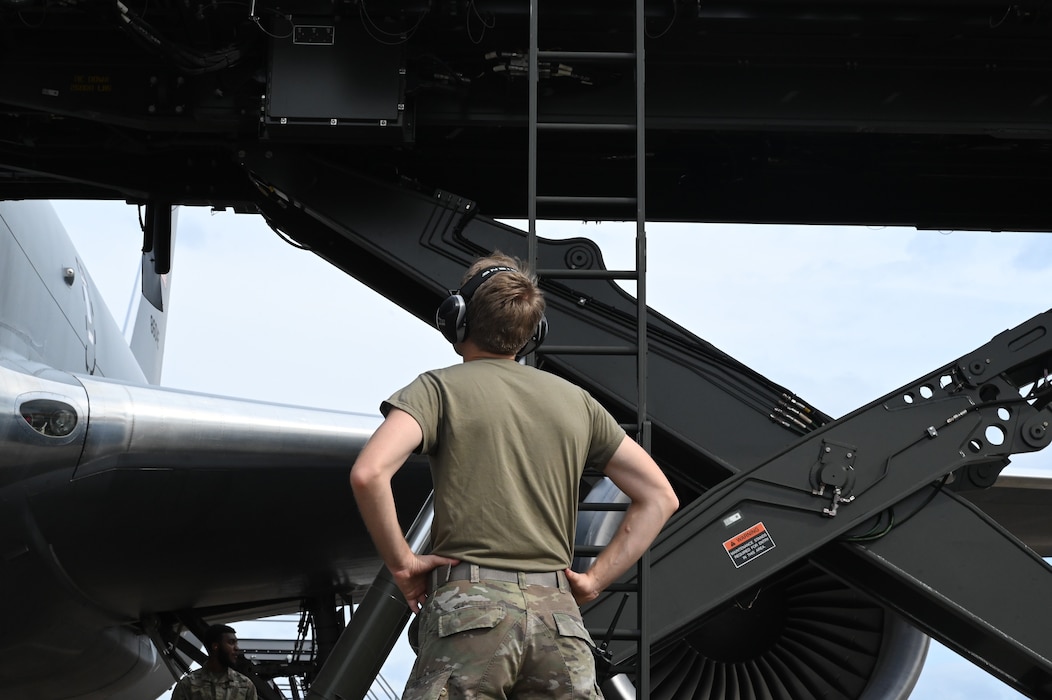 a person watches a lift reach an aircraft.