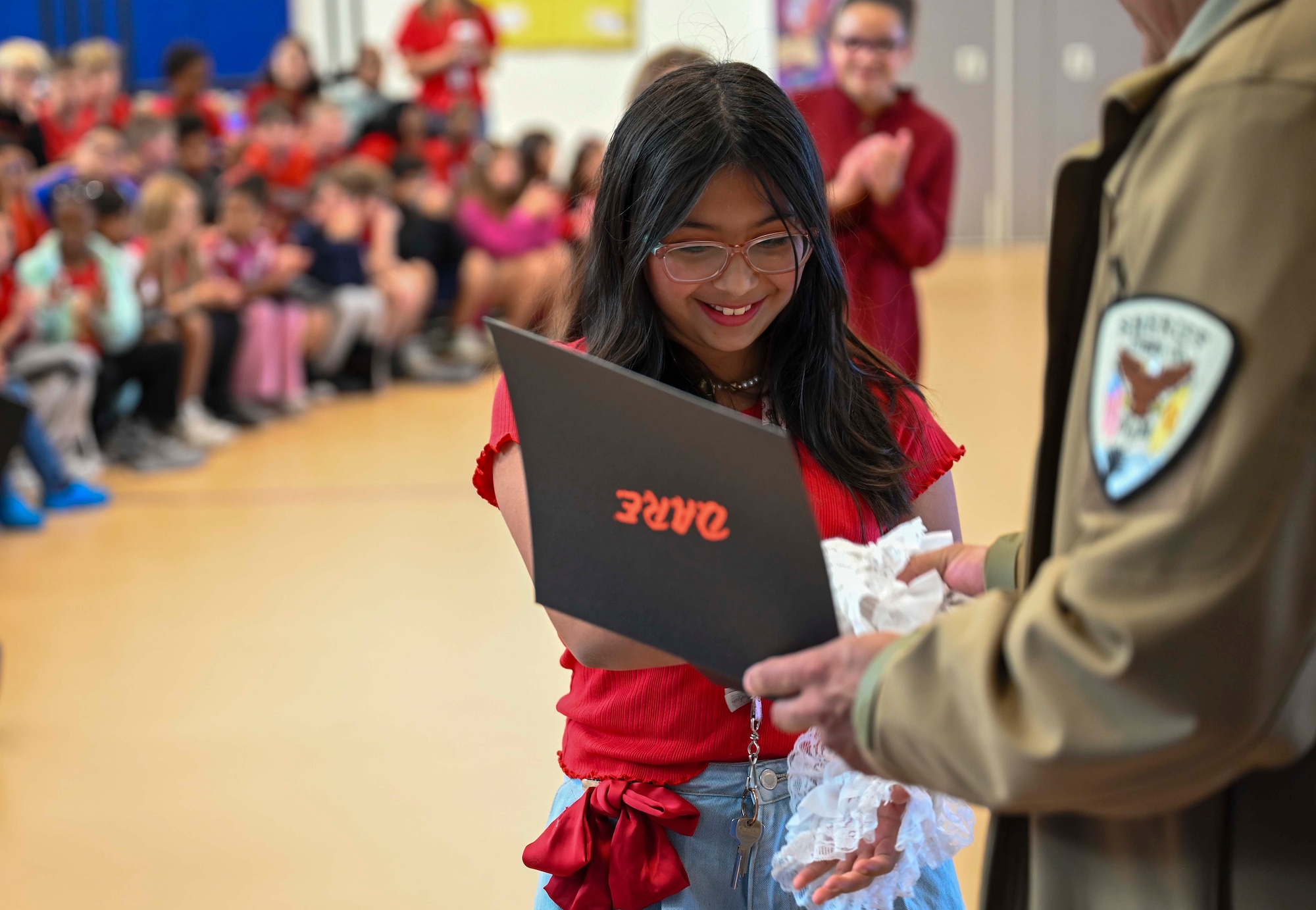 A Drug Abuse Resistance Education graduate receives a certificate of completion from Otero County sheriff team at Holloman Air Force Base, New Mexico, Oct. 31, 2024. The D.A.R.E. program is a well-designed multicultural curriculum that aligns with developmental needs and equips young people with essential skills to ensure they lead safe, healthy, and responsible lives, free from substance abuse. (U.S. Air Force photo by Airman 1st Class Michelle Ferrari)