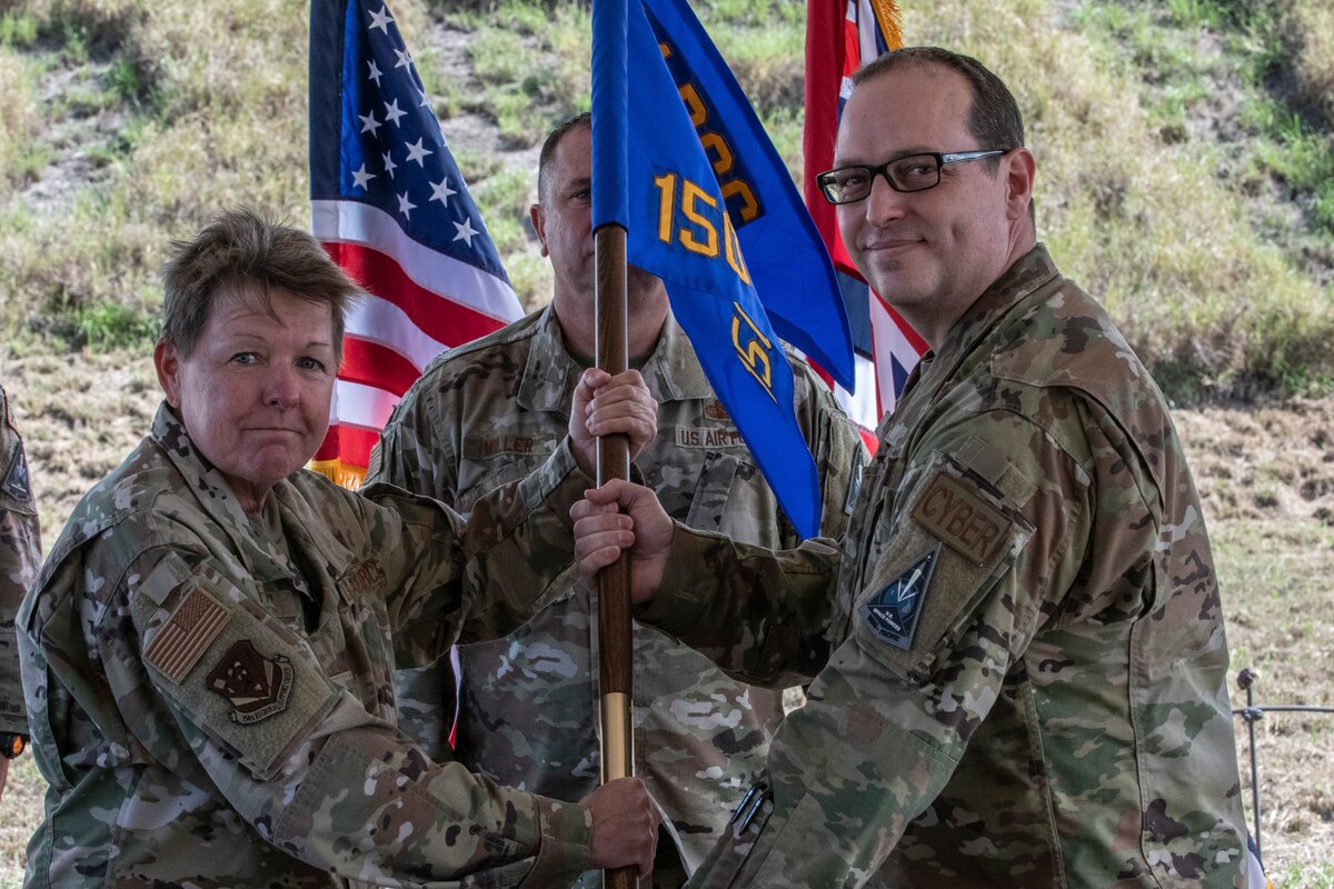 U.S. Air National Guard Col. Kathleen Fallis, 154th Regional Support Group commander, confers leadership to U.S. Air National Guard Maj. Joseph Hale, 150th Electromagnetic Warfare Squadron commander, at Pacific Missile Range Facility, Hawaii, Nov. 1, 2024. The 150th EWS mission is to deliver offensive electronic combat effects and space domain awareness to support global and theater campaigns.