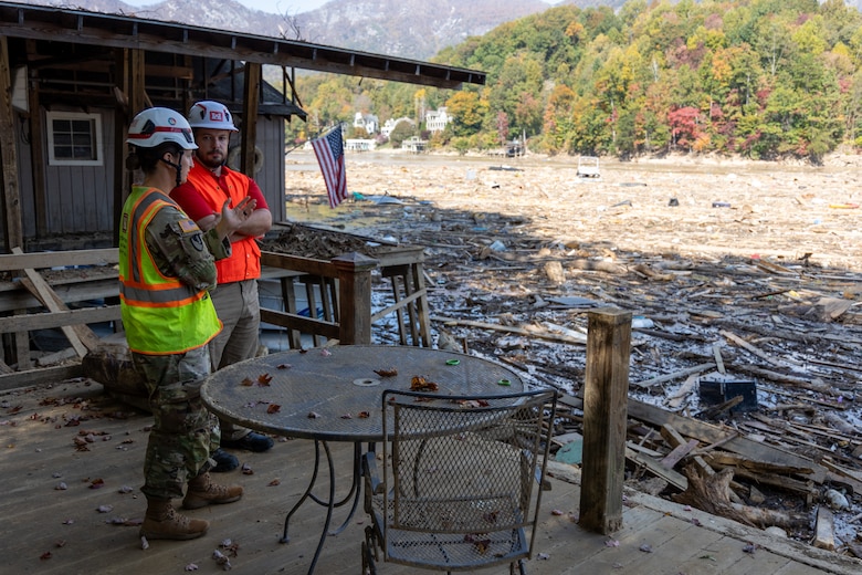 Maj. Brittany Hine, U.S. Army Corps of Engineers, speaks with Justin Gibson, a member of Task Force Debris, while assessing storm debris along the lakefront at Lake Lure, North Carolina, Oct. 26, 2024. The U.S. Army Corps of Engineers is partnering with local agencies to support community recovery and debris removal operations.