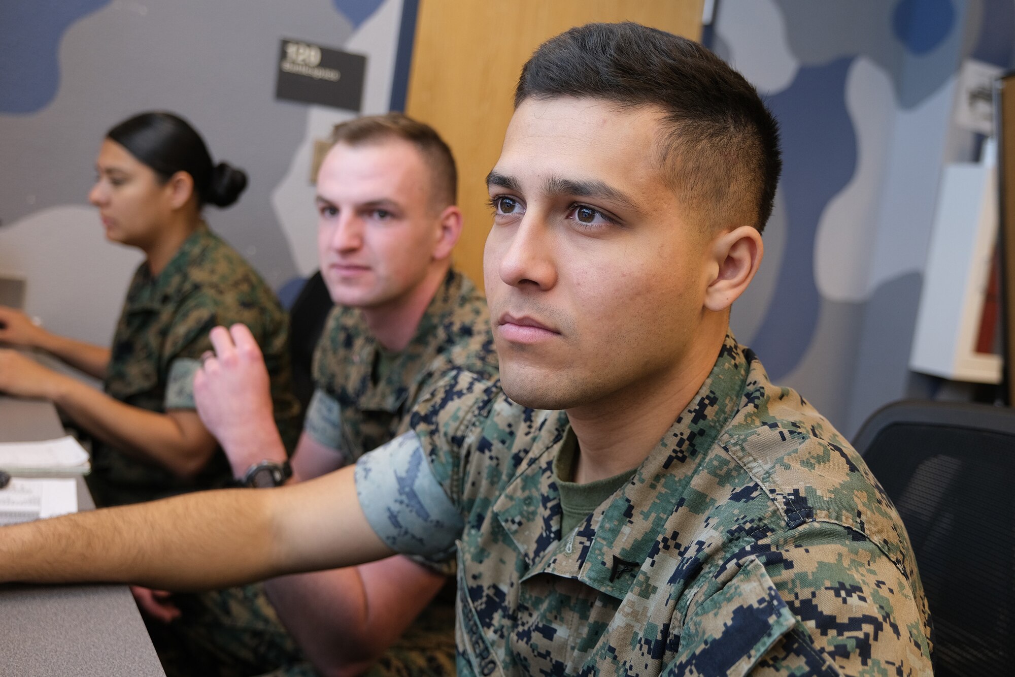 uniformed U.S. Marines work in a virtual simulated environment
