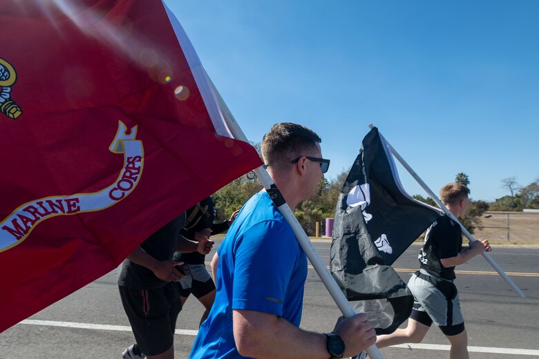 U.S. Marines with Marine Aerial Refueler Transport Squadron (VMGR) 352, Marine Aircraft Group 11, 3rd Marine Aircraft Wing, participate in a Veteran's Day flag run in San Diego, Nov. 7, 2024. The run, spearheaded by Capt. Tyler Chittick, began at MCAS Miramar and will end at the School of Infantry West, Marine Corps Base Camp Pendleton totaling 55 miles of relay run and hike. Each year Chittick brings Marines together to complete a challenging physical activity in honor of fallen and disabled veterans including a fellow Marine who was injured by an improvised explosive device in Afghanistan in 2011. (U.S. Marine Corps photo by Gunnery Sgt. Antonio De La Fuente)