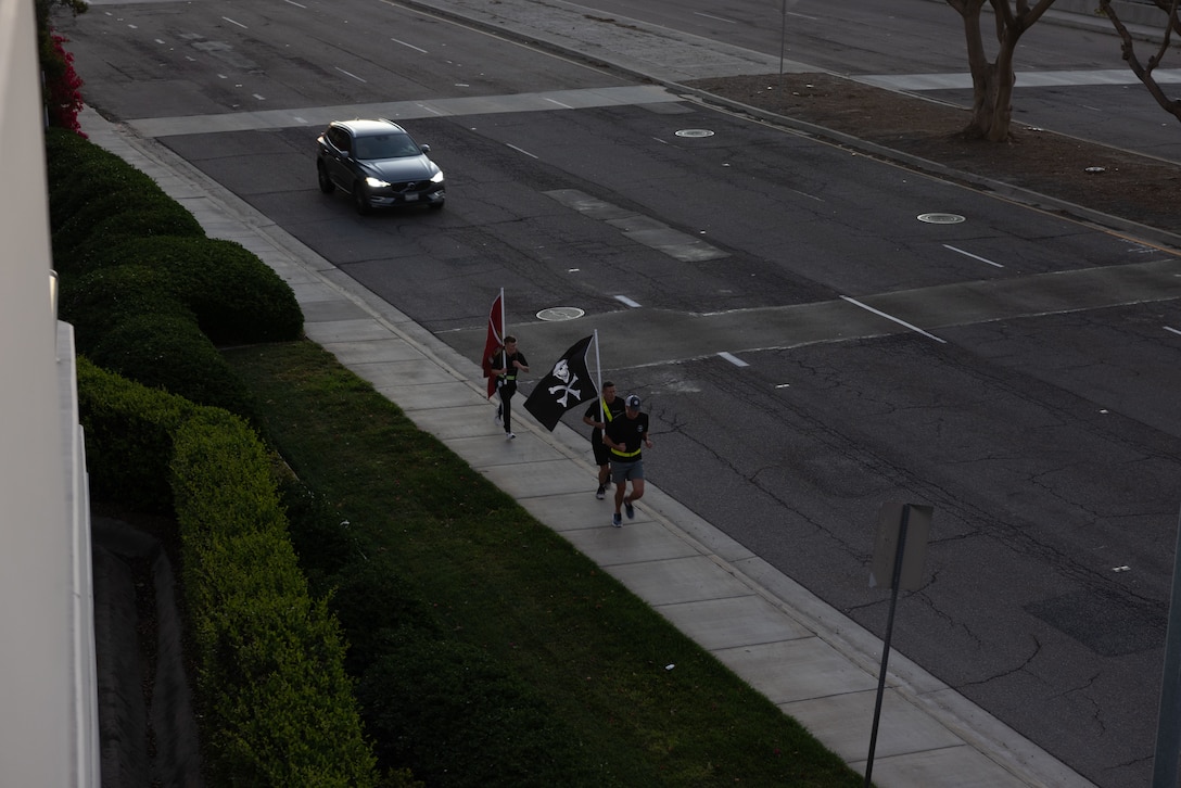 U.S. Marine Corps Lt. Col. Mark Bock Jr., front, the commanding officer of Marine Aerial Refueler Transport Squadron (VMGR) 352, Marine Aircraft Group 11, 3rd Marine Aircraft Wing, participate in a Veteran's Day flag run alongside Marines with VMGR-352 in San Diego, Nov. 7, 2024. The run, spearheaded by Capt. Tyler Chittick, began at MCAS Miramar and will end at the School of Infantry West, Marine Corps Base Camp Pendleton totaling 55 miles of relay run and hike. Each year Chittick brings Marines together to complete a challenging physical activity in honor of fallen and disabled veterans including a fellow Marine who was injured by an improvised explosive device in Afghanistan in 2011. (U.S. Marine Corps photo by Gunnery Sgt. Antonio De La Fuente)