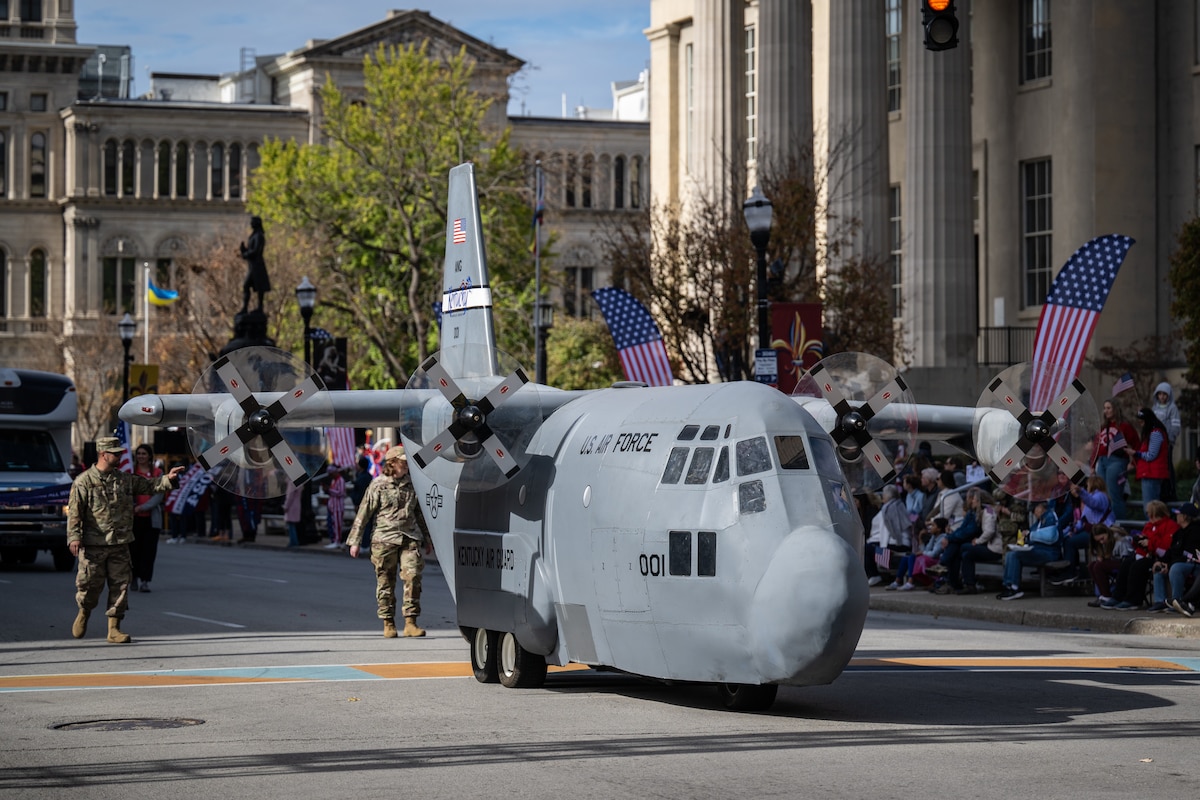 The Kentucky Air National Guard’s Mini C-130 taxies along Jefferson Street in downtown Louisville, Ky., Nov. 9, 2024, as part of the city’s annual Veterans Day Parade. The non-flying scale replica of a C-130 Hercules transport aircraft was fabricated by Airmen from the unit’s 123rd Maintenance Group. (U.S. Air National Guard photo by Dale Greer)