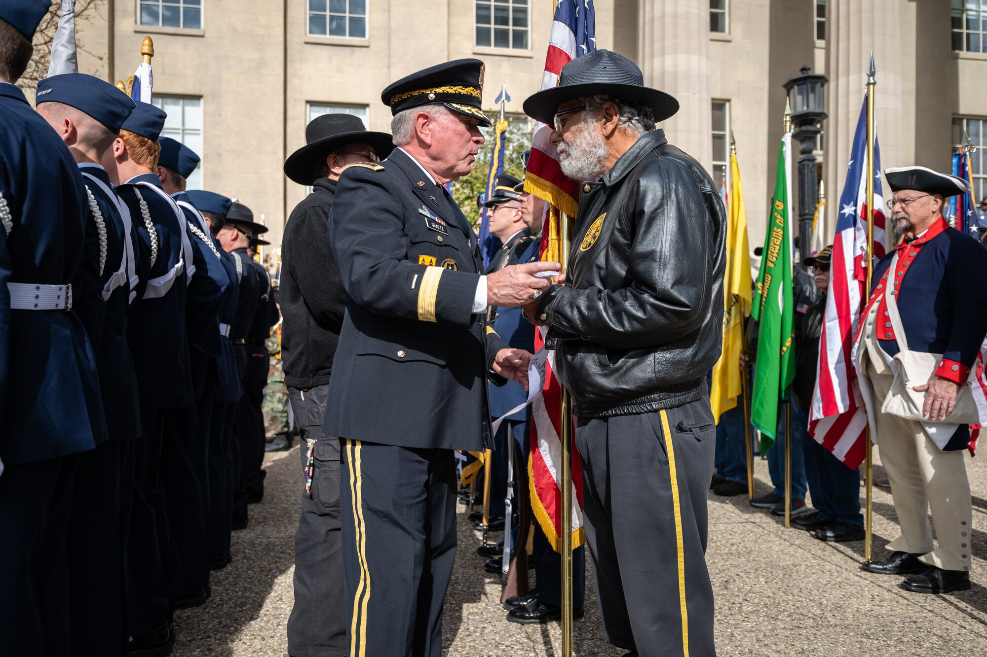 U.S. Army Chaplain Brig. Gen. David Graetz, retired, a former Kentucky National Guardsman who served as assistant to the Army chief of chaplains, presents veterans with memorial ribbons during the annual Veterans Day Parade in downtown Louisville, Ky., Nov. 9, 2024. The event, which drew thousands of spectators, featured appearances by more than 50 veterans groups, military units and civic organizations. (U.S. Air National Guard photo by Dale Greer)
